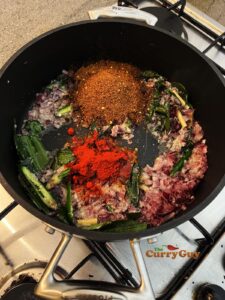 Adding ground spices to pan.