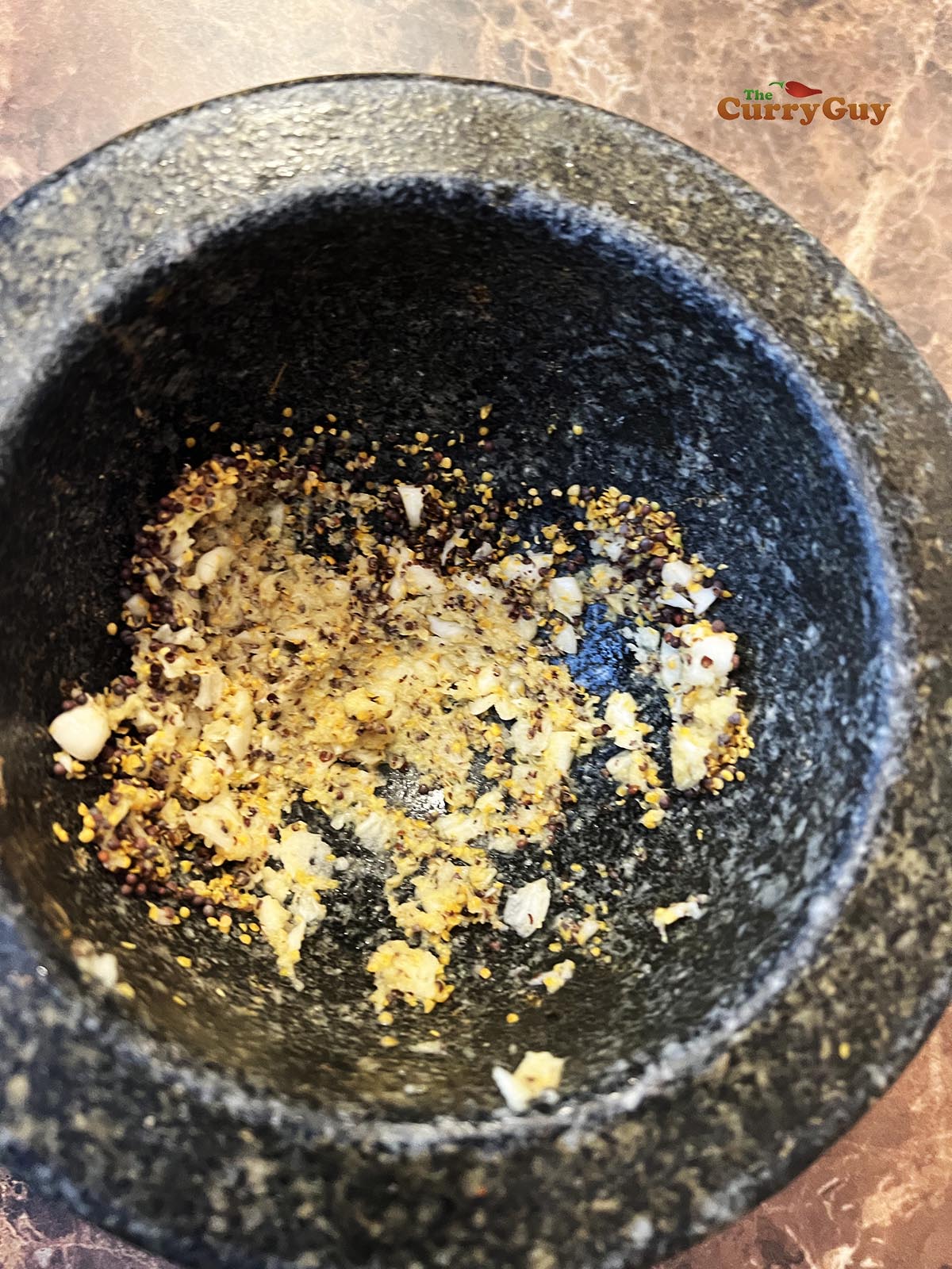 Adding garlic and ginger to pestle and mortar