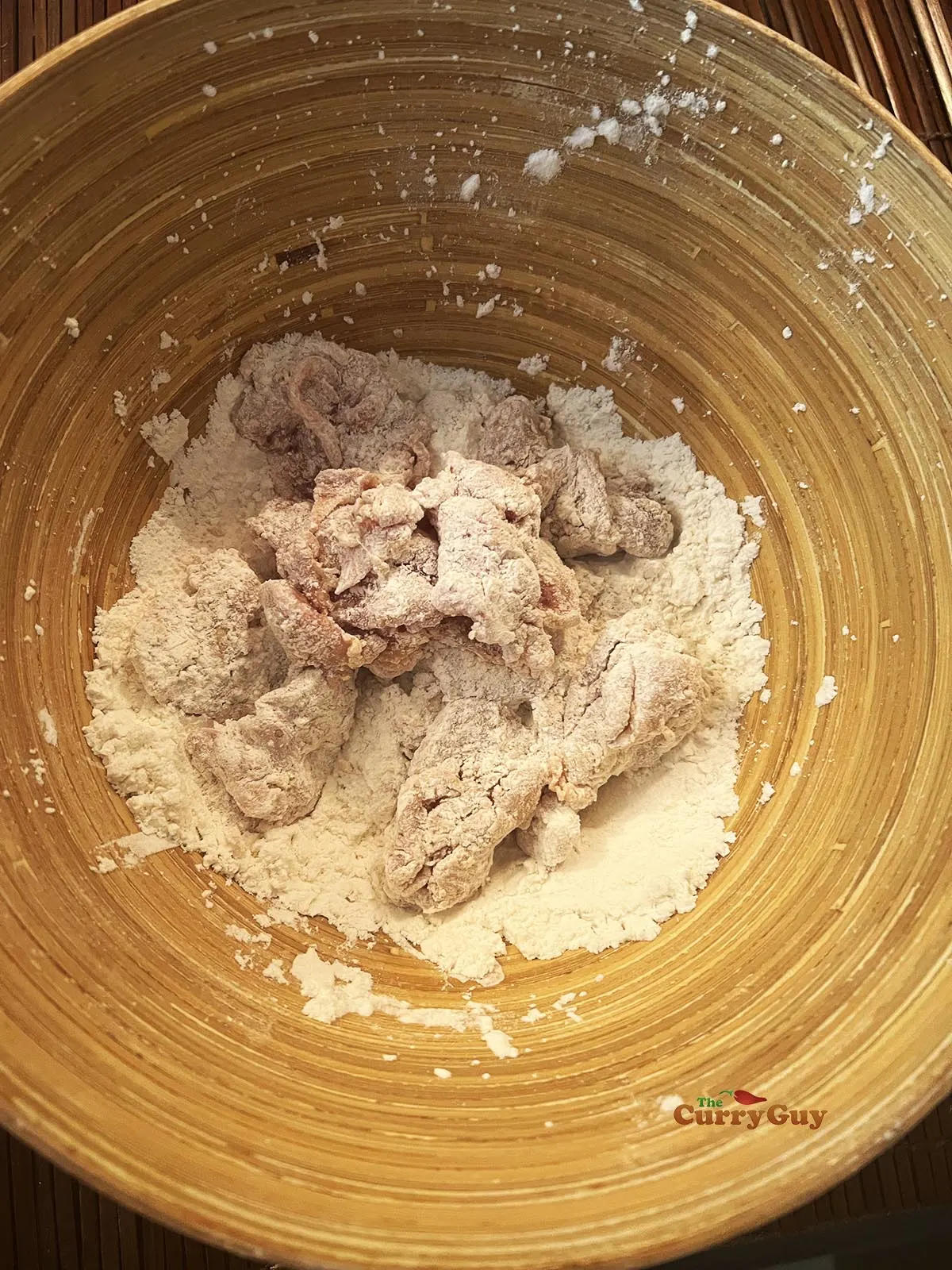 Coating the marinated chicken with flour