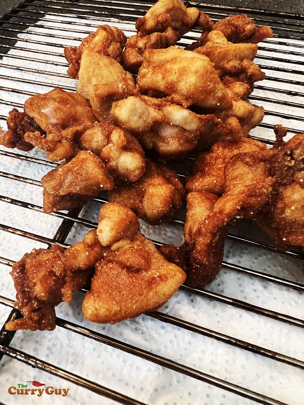 Fried chicken resting on a rack.
