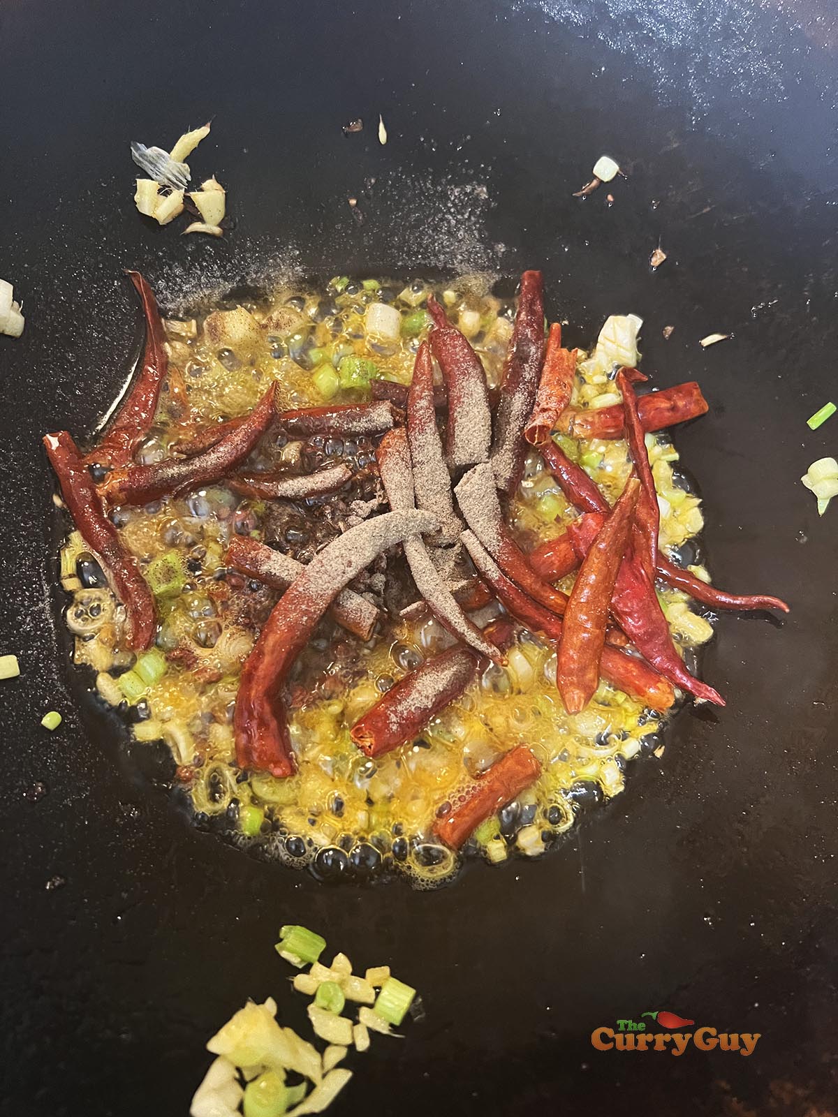Adding dried chillies and white pepper