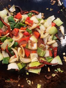 Adding veggies to Szechuan chicken