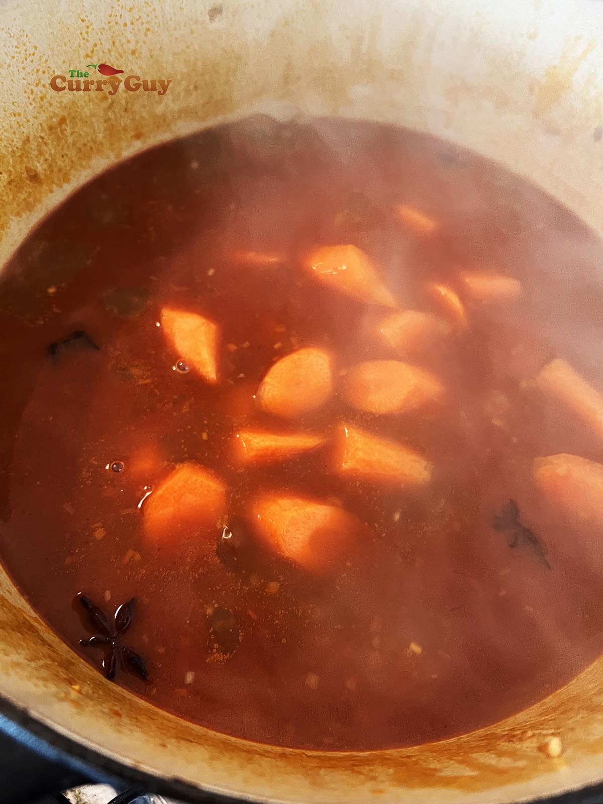 Finishing Bo Kho by simmering in coconut water