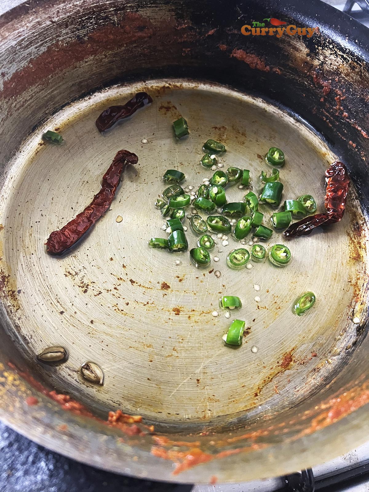 Infusing spices and chillies into oil in the pan