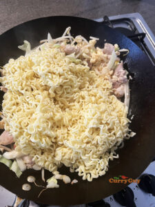Adding noodles to the wok
