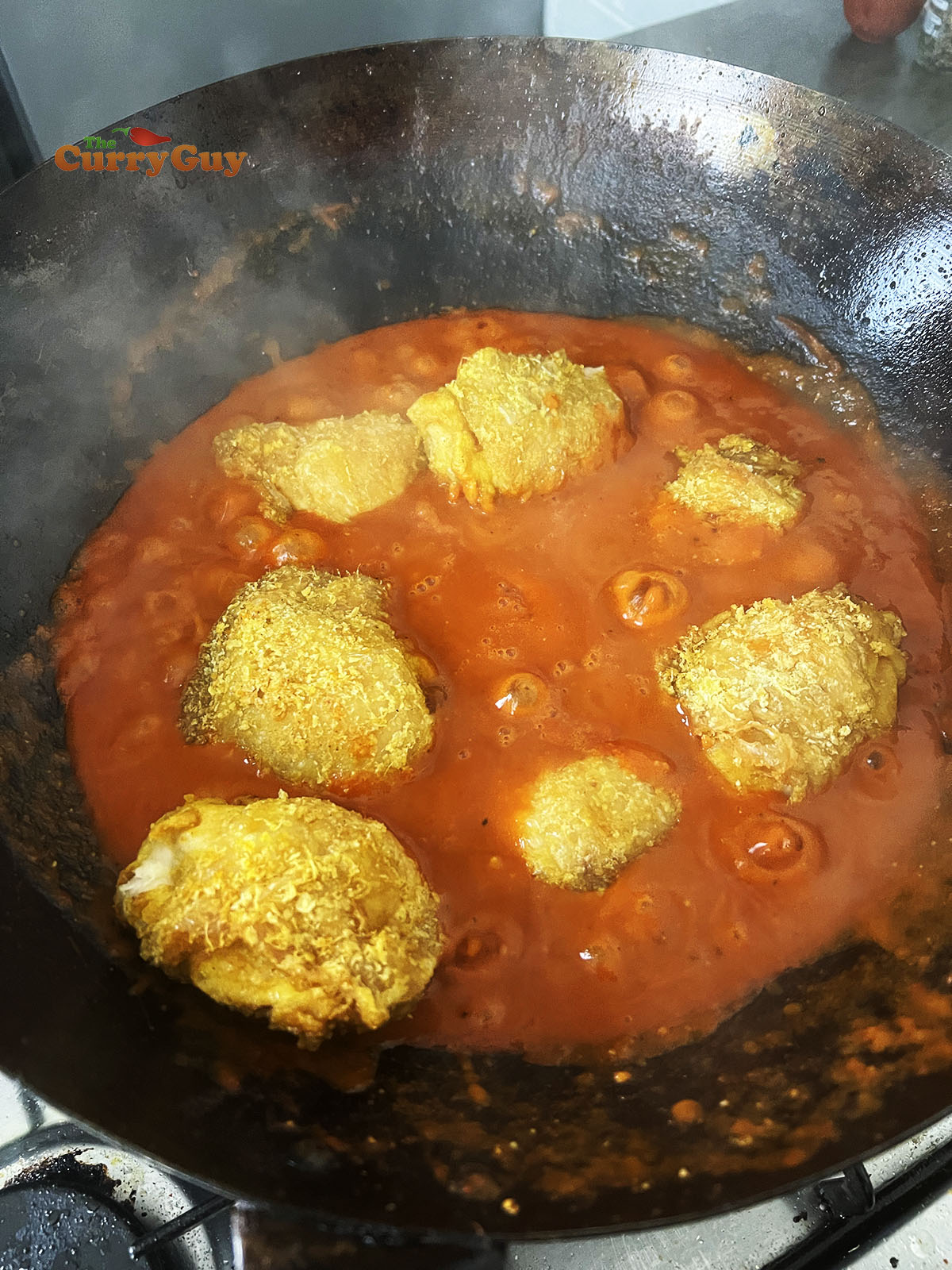 Adding chicken to the wok and sauce