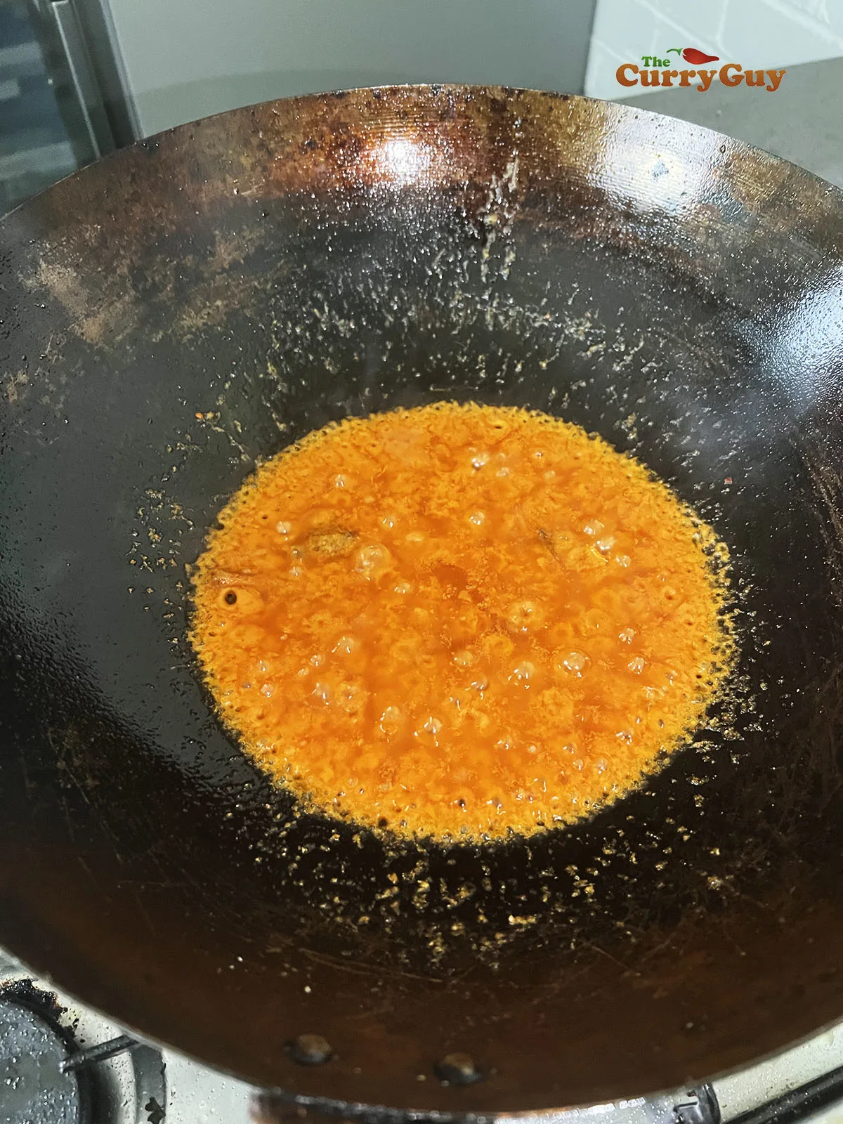 Adding curry paste to the wok