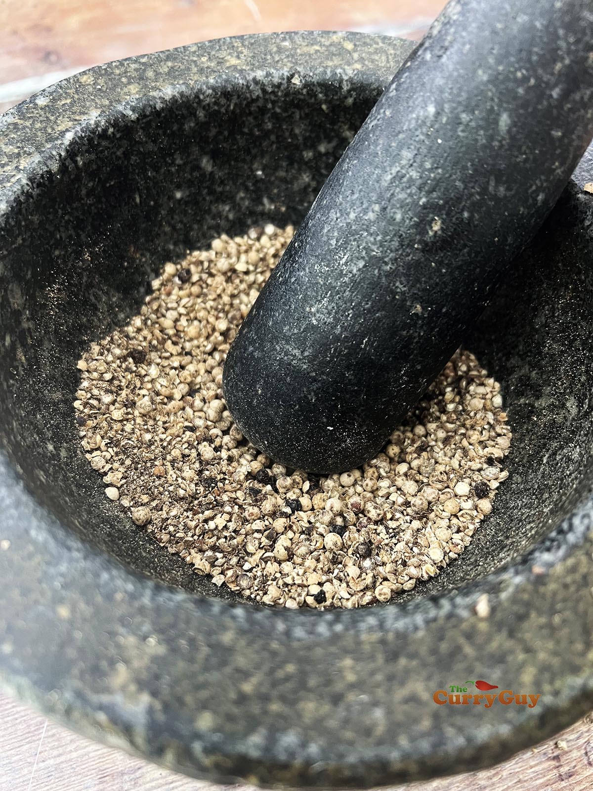 Grinding white and black peppercorns
