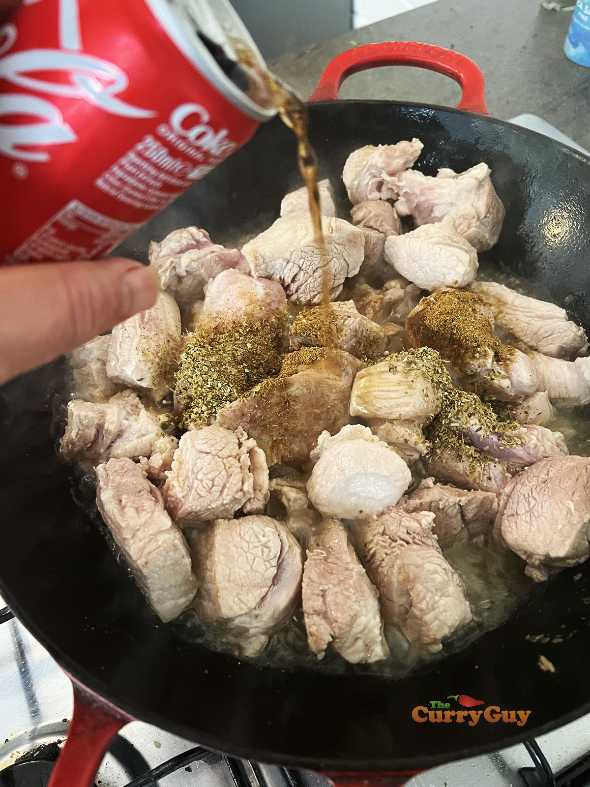Adding coke, milk, orange juice and spices to the wok
