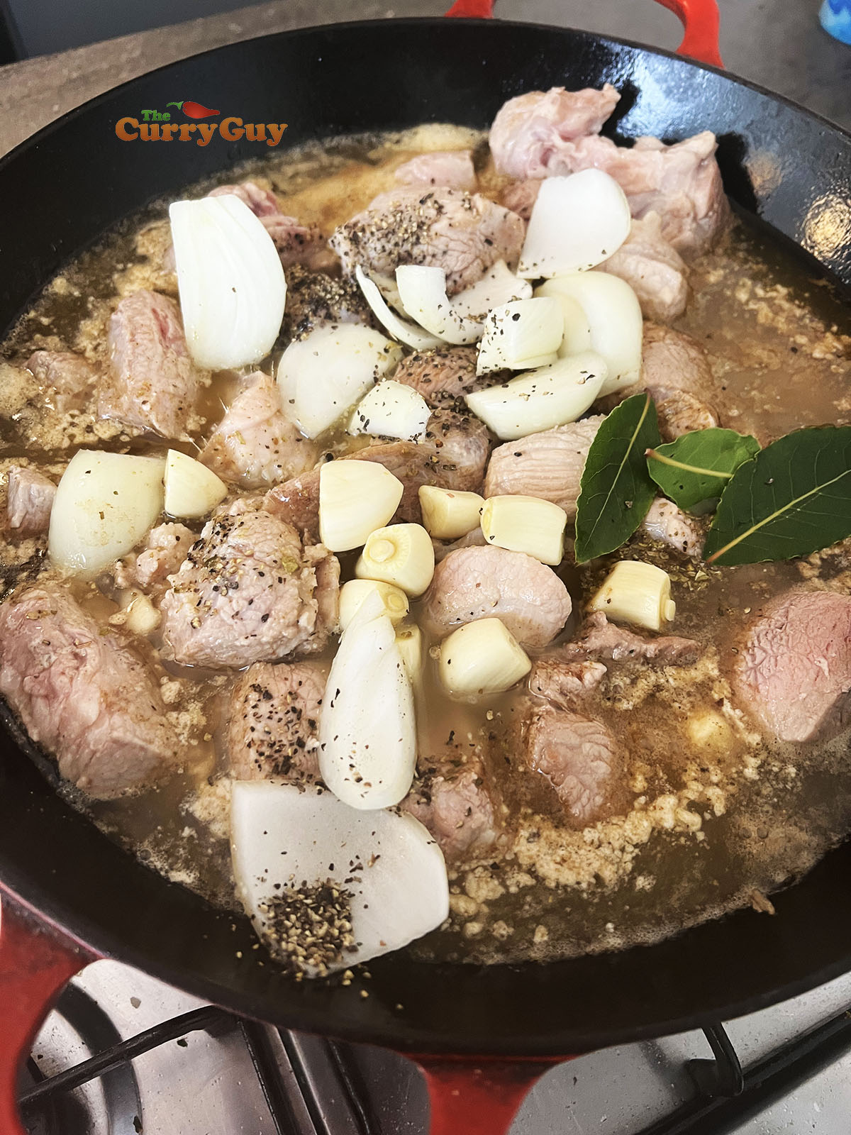 Adding garlic, onion and bay leaves to the pan