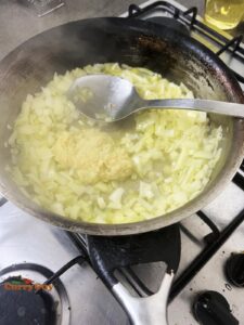 Stirring garlic and ginger paste into the pan