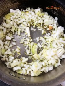 Adding chopped onions to frying pan