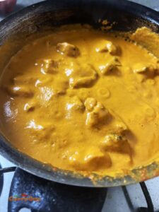 adding cream to chicken tikka masala