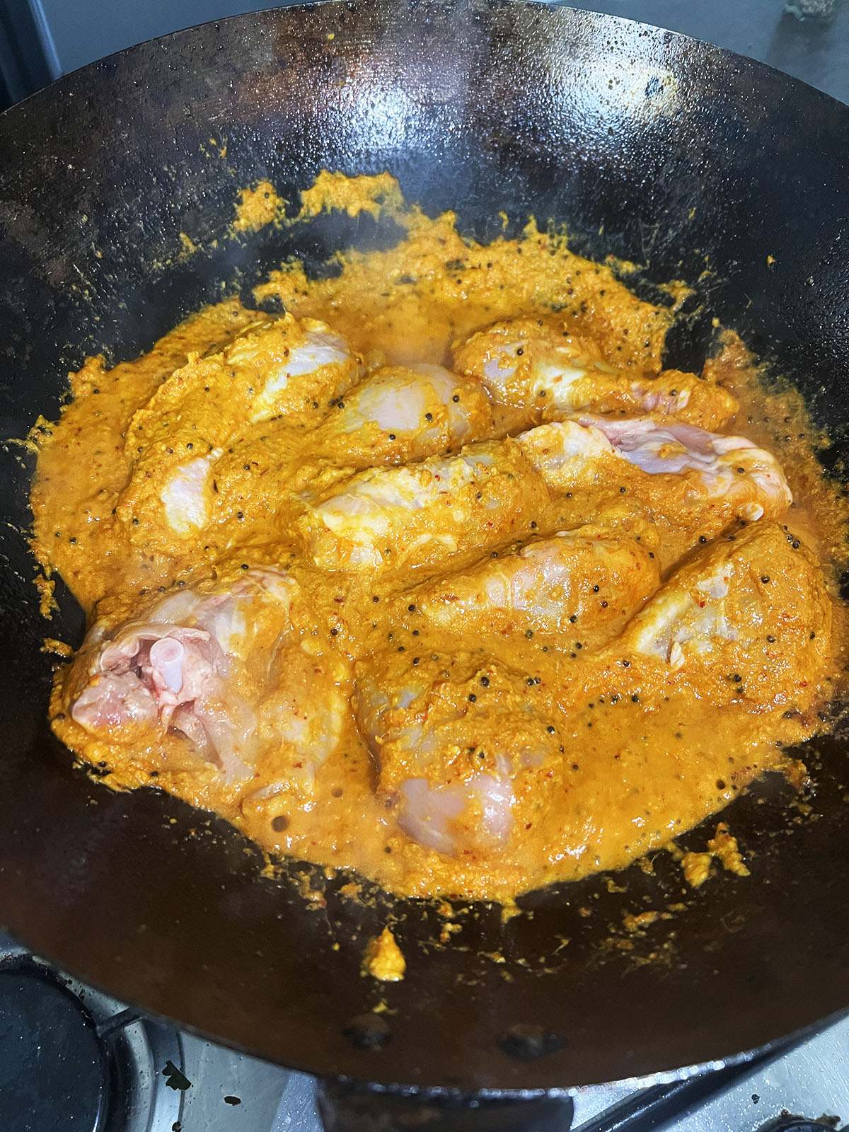 Adding marinated chicken to the sauce