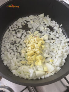 Adding onions, garlic and ginger to the pan