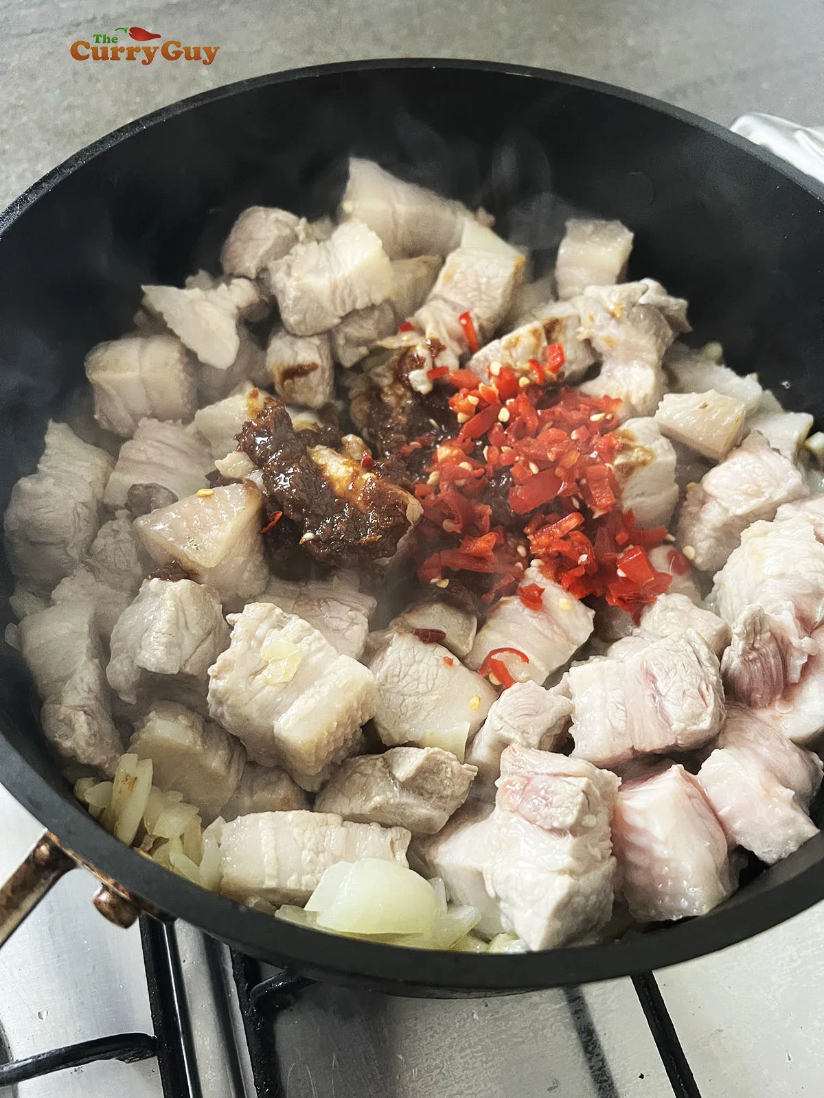 Stirring the shrimp paste and red chillies to the pan