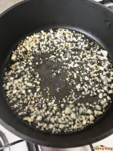 Frying garlic in oil to brown it.