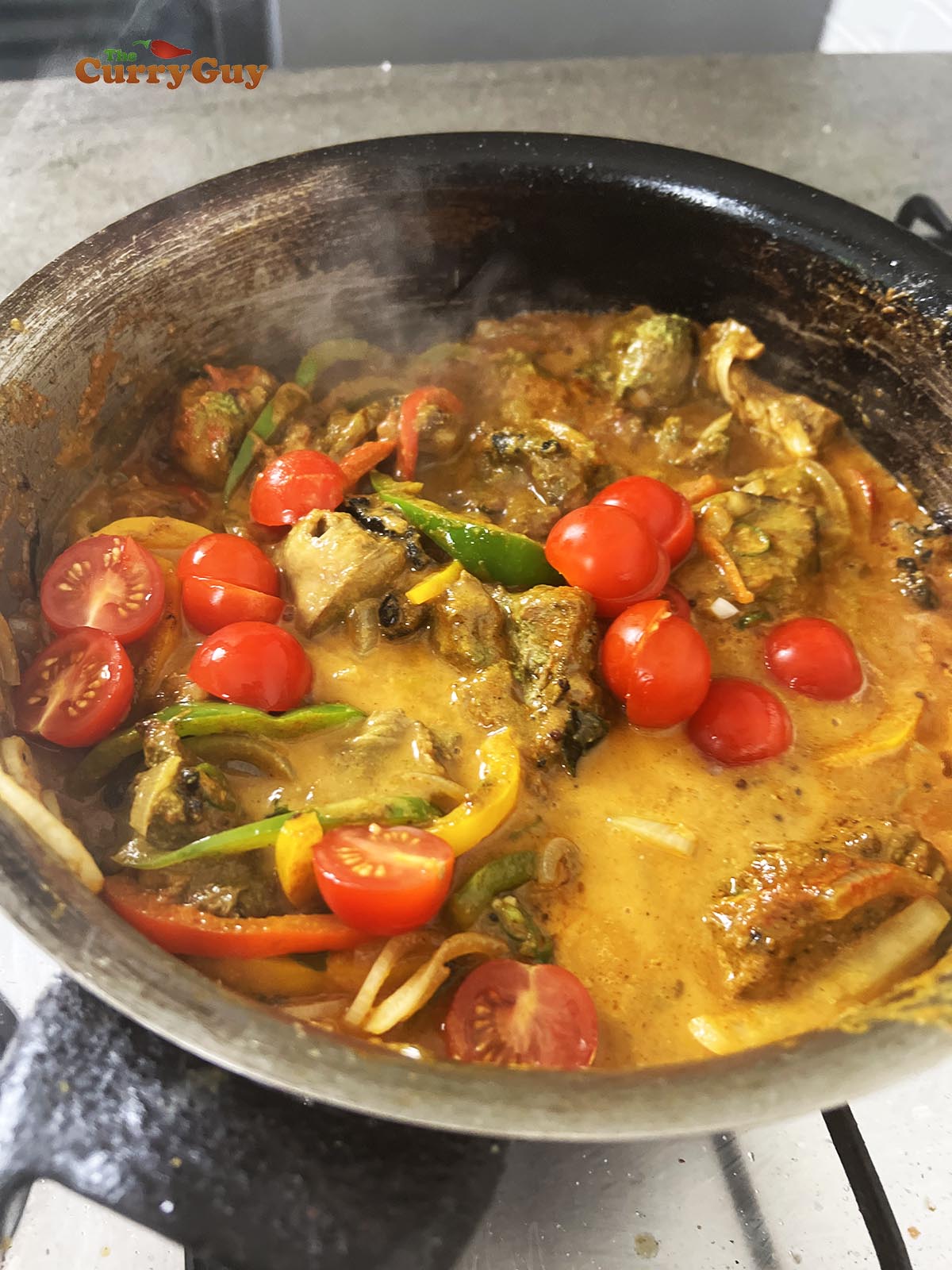 Adding chicken and tomatoes to the pan