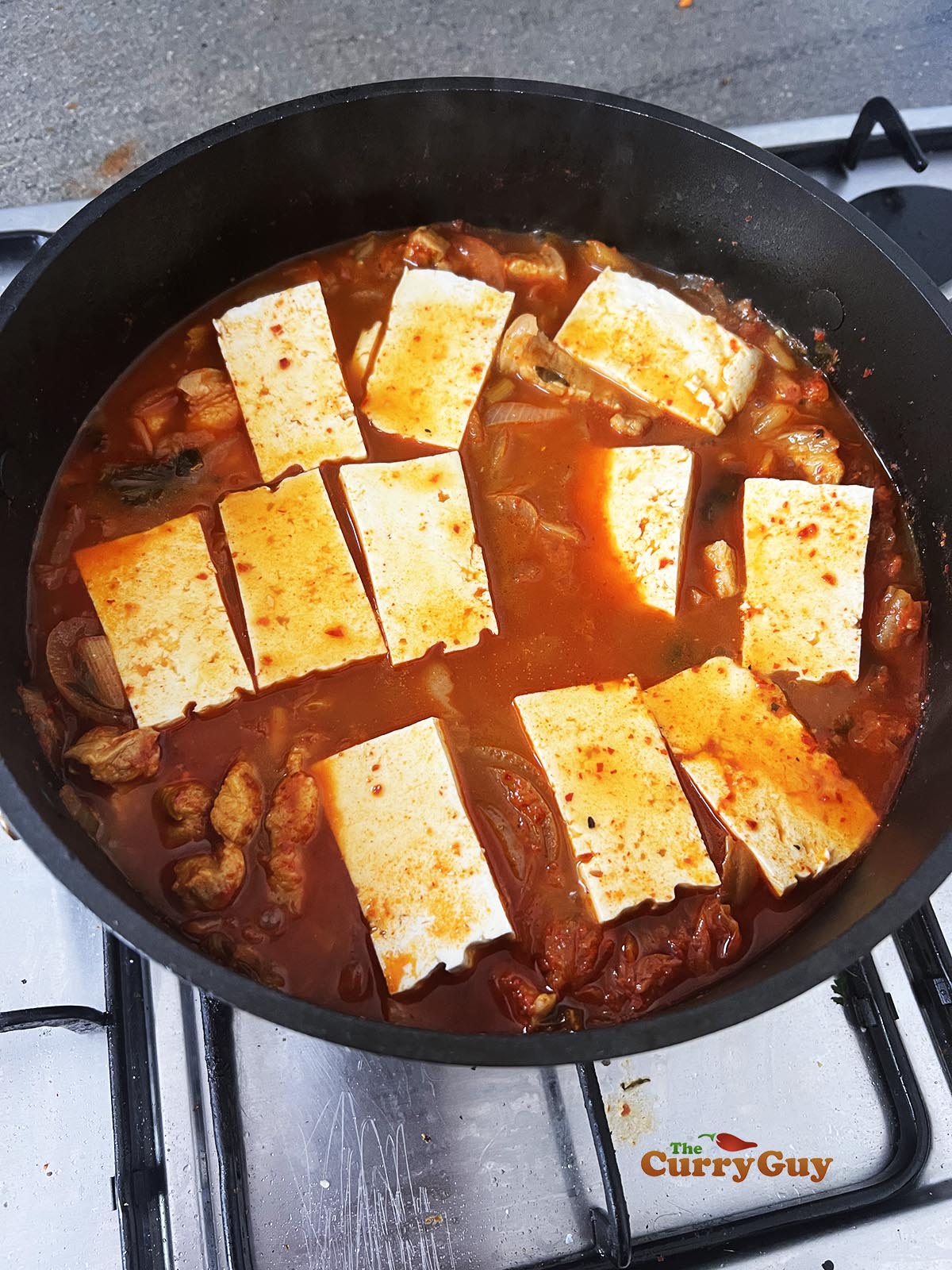 Adding tofu to the pot