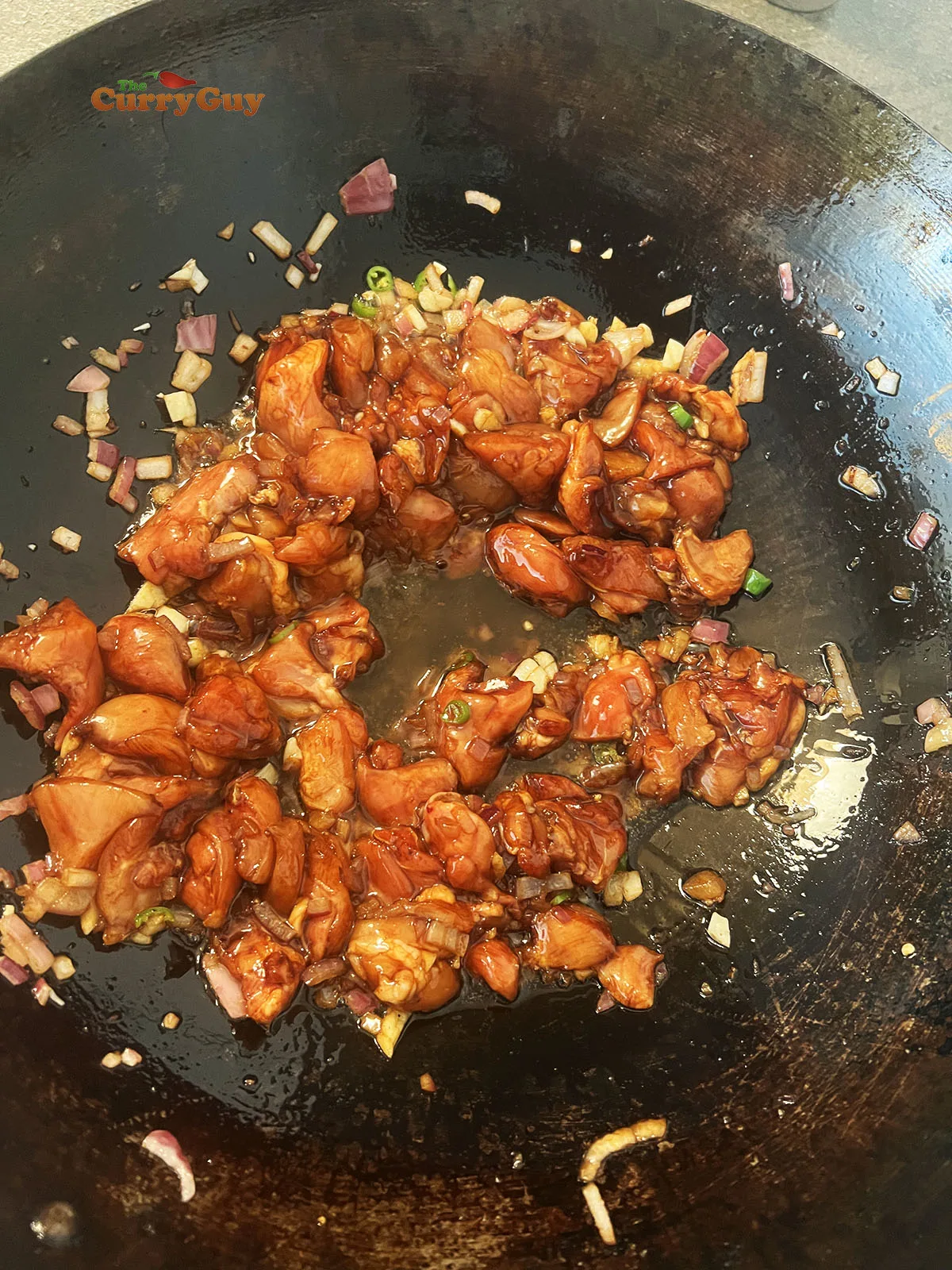 Adding chicken to the wok
