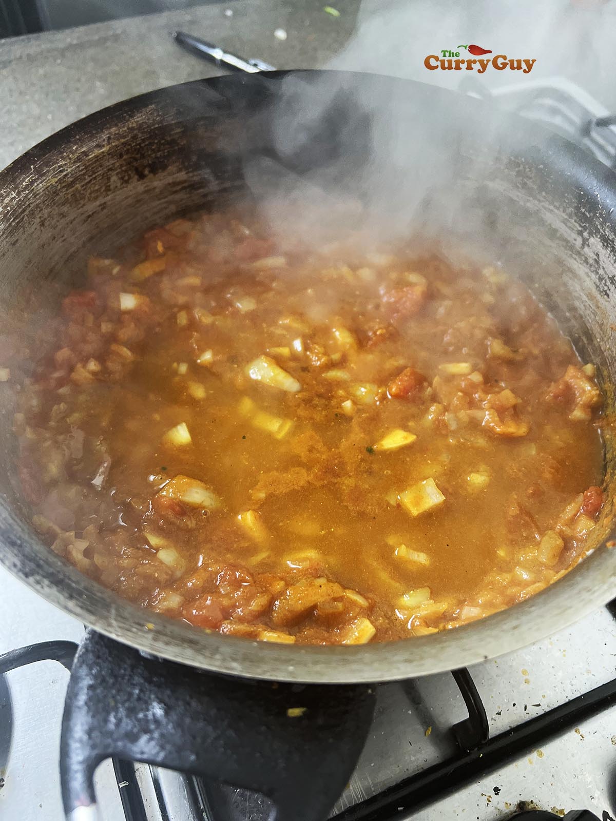 Adding mango chutney and stock to the pan