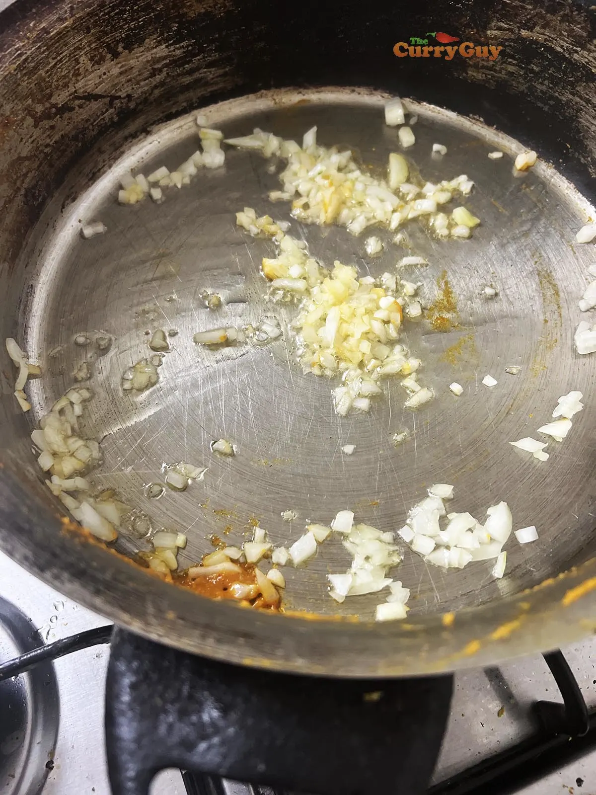 Adding chopped onion to the pan.