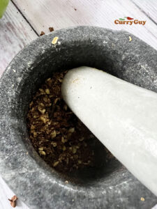 Pounding Szechuan peppercorns in a pestle and mortar