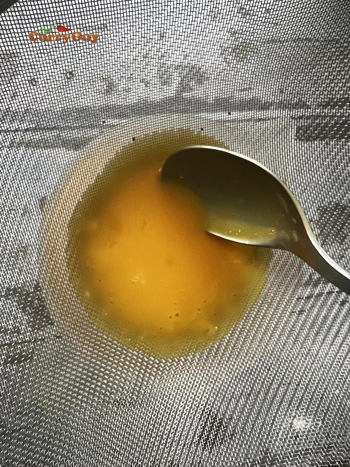Putting egg yolks through a sieve.