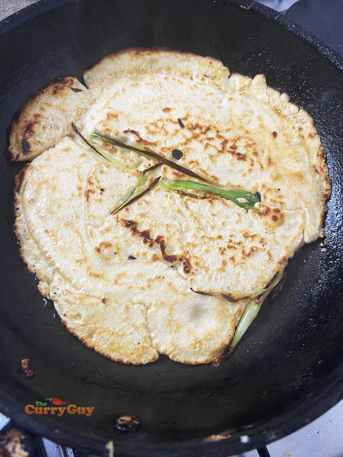 Korean pancake flipped over to cook the other side.