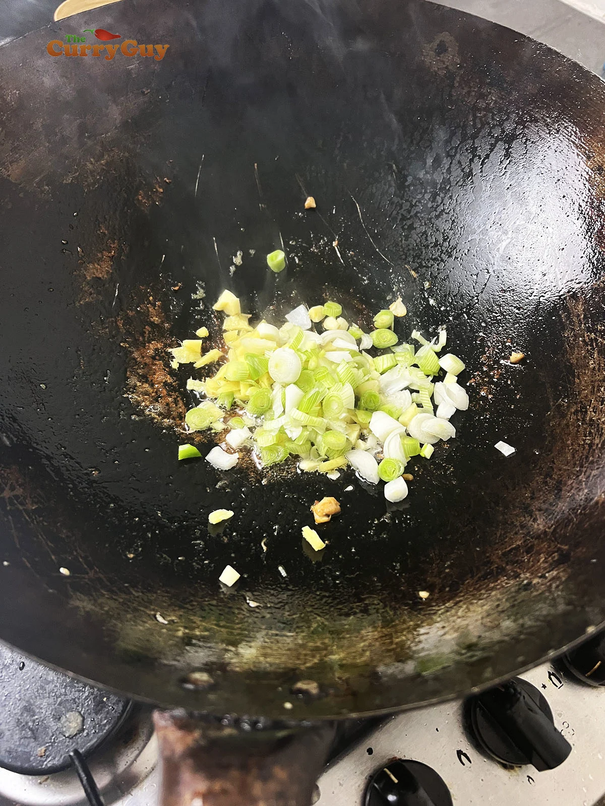 Frying aromatic ingredients in the wok.