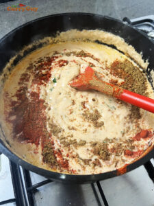 Adding spices to the sauce.
