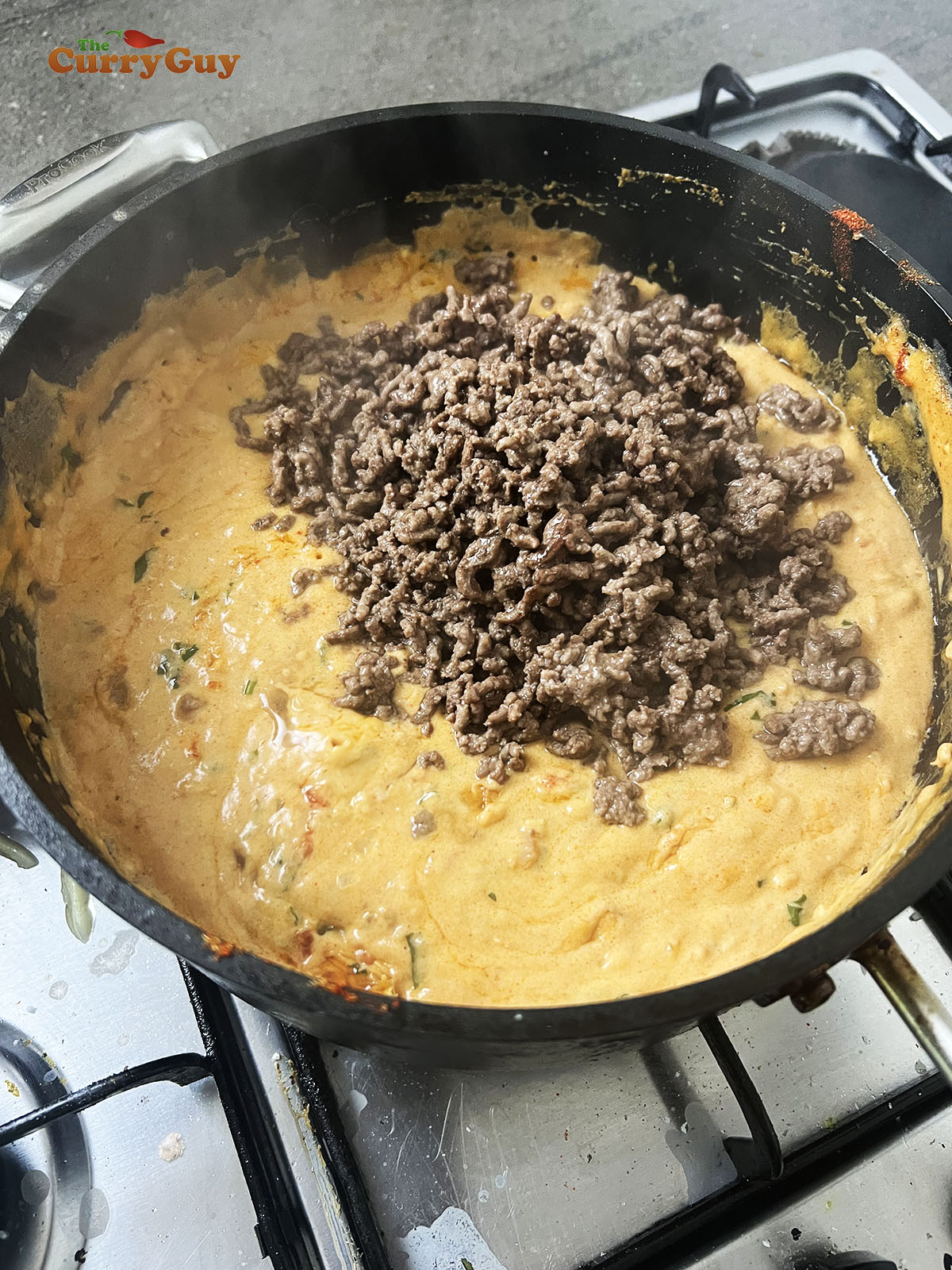 Adding cooked ground beef to the sauce