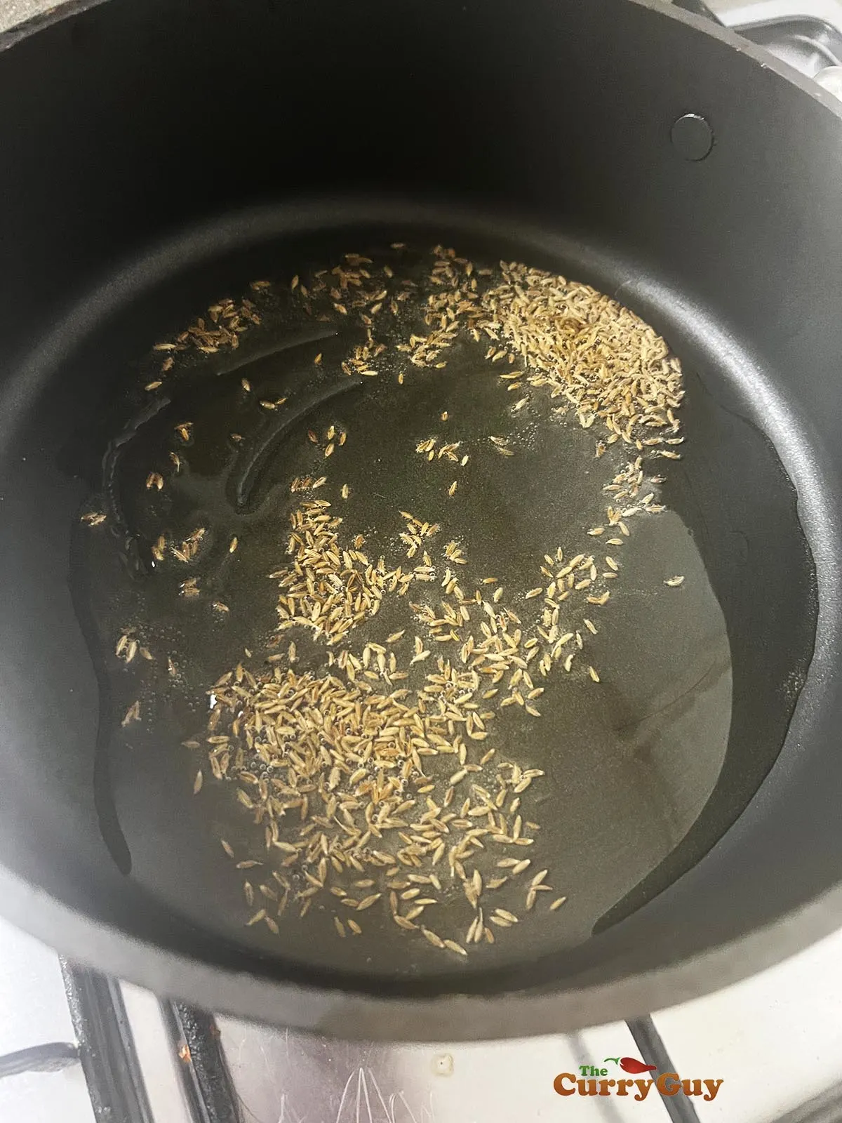 Infusing cumin seeds in the hot oil.