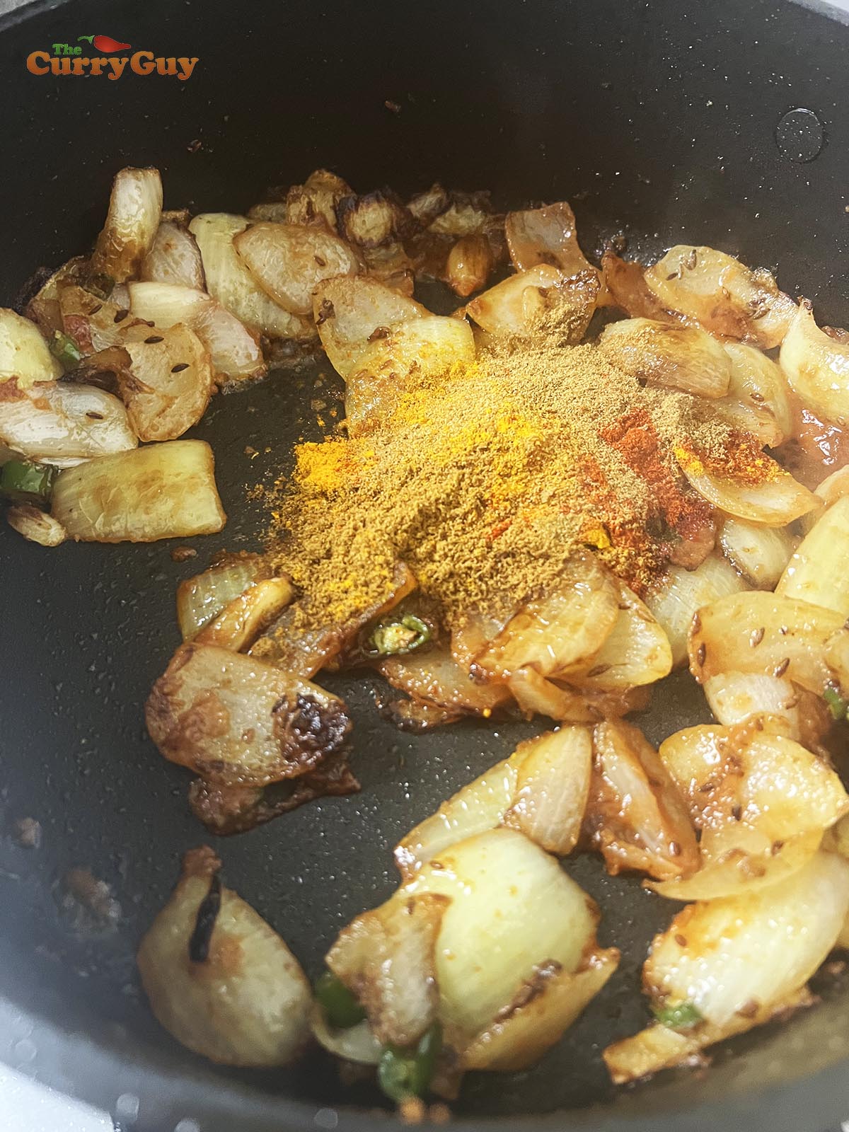 Adding ground spices to the curry