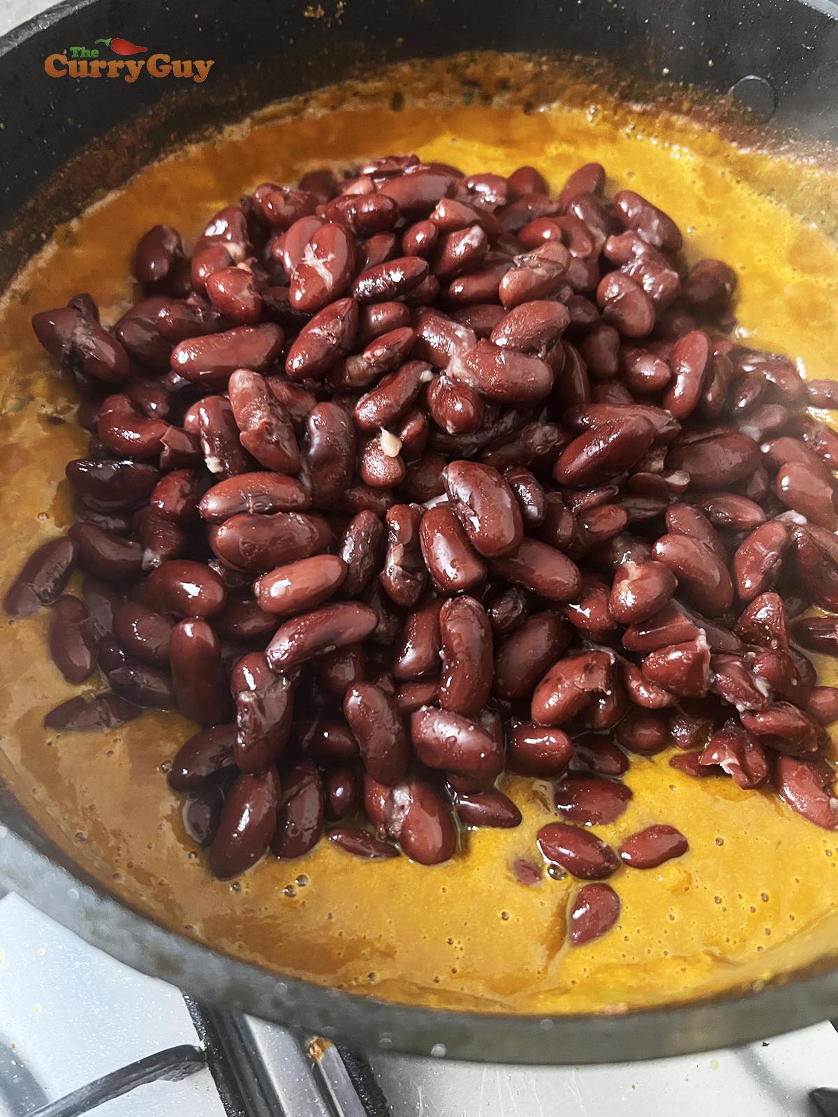 Adding kidney beans to the blended sauce.