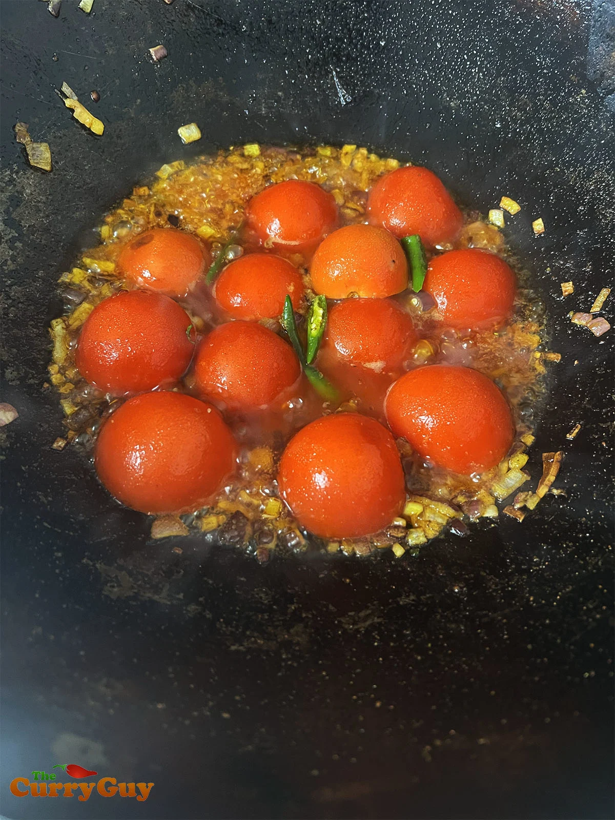 Adding tomatoes to the karahi
