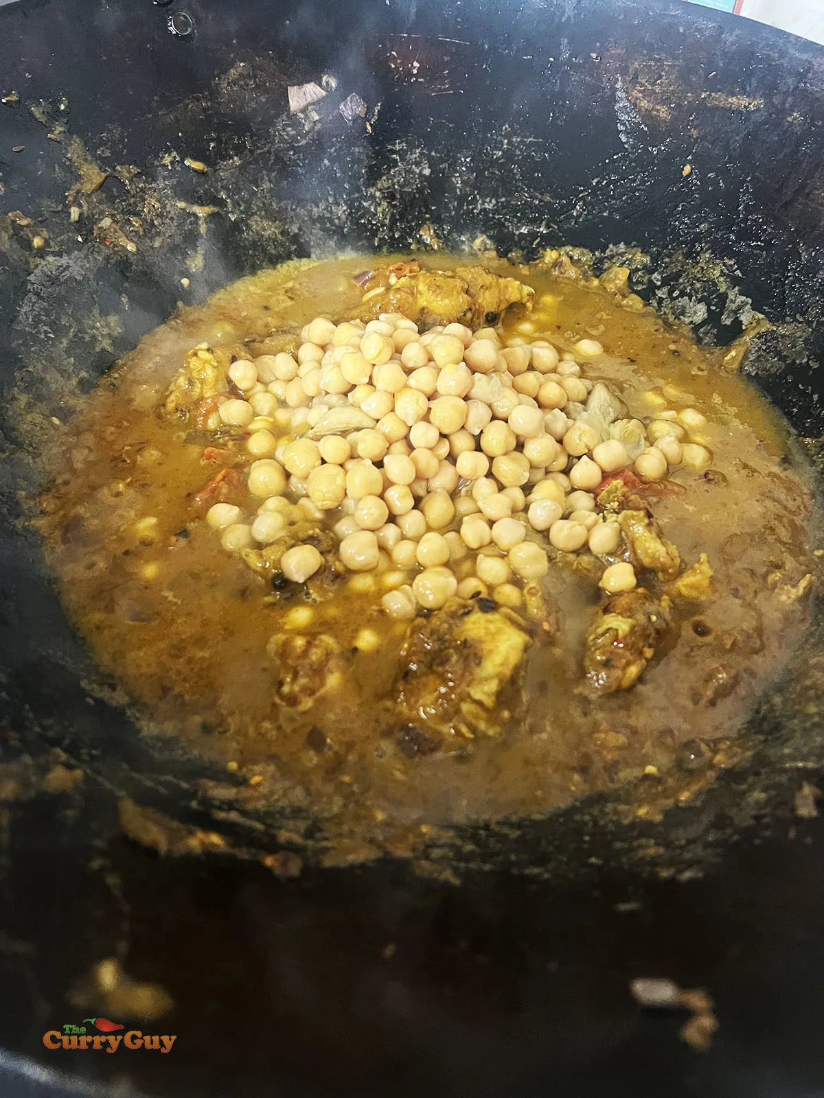 Adding the chickpeas to the pan.
