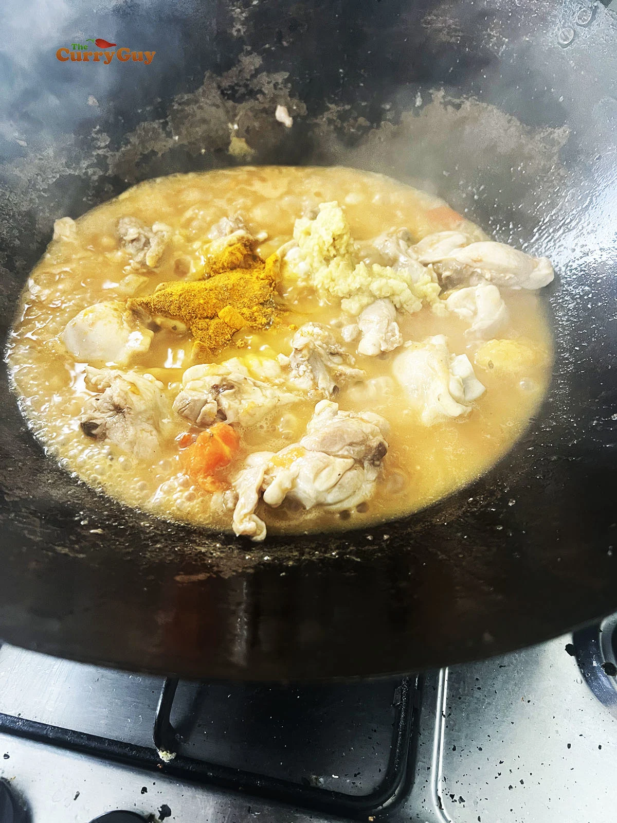 Adding garlic and ginger paste, spices and water to the chicken karahi