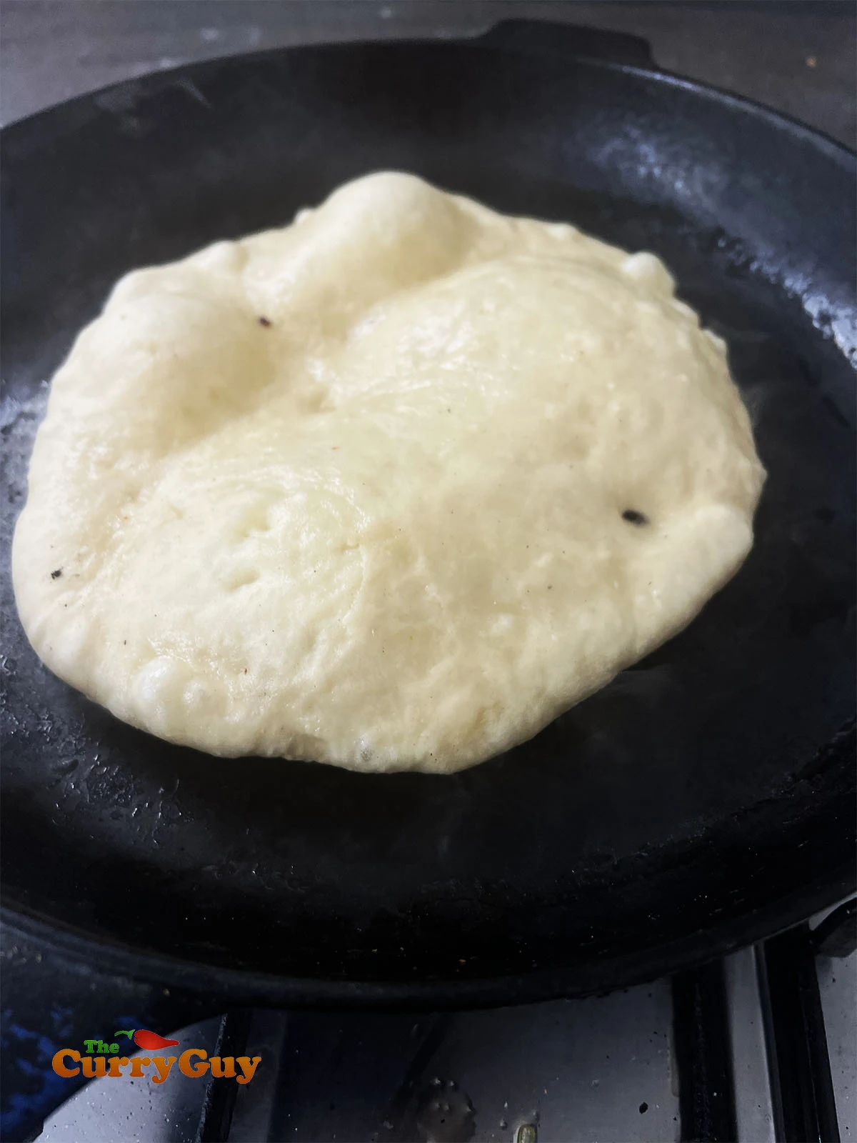 The naan bubbling up in the pan.