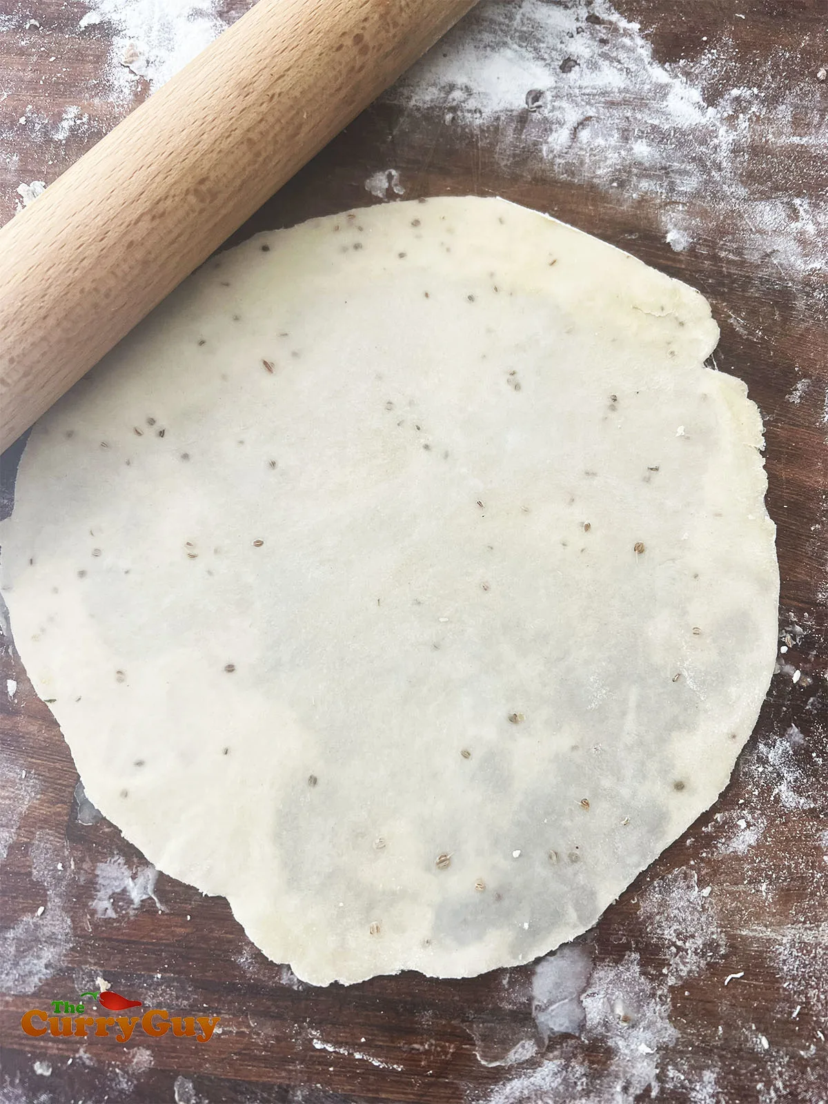 Rolling the pastry out into a round samosa wrapper.