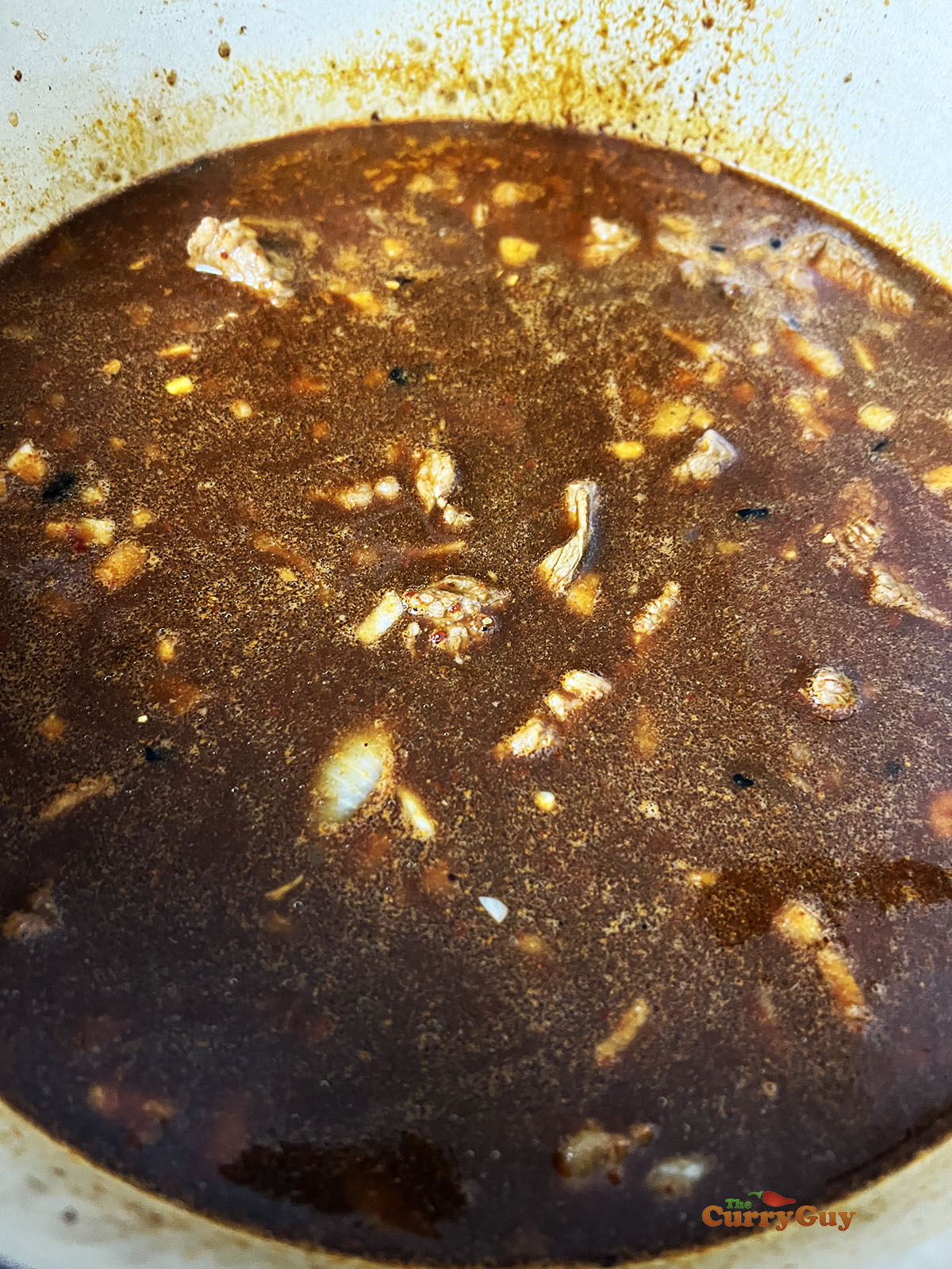 Adding stock and meat to the pot.