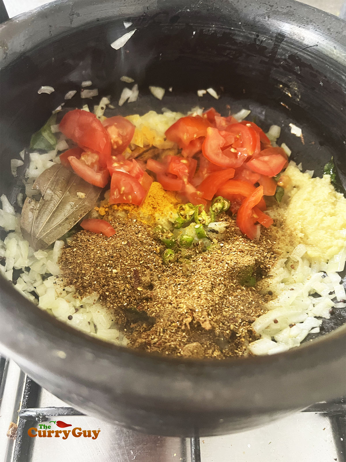 Adding the ground spices, tomatoes and garlic and ginger paste.