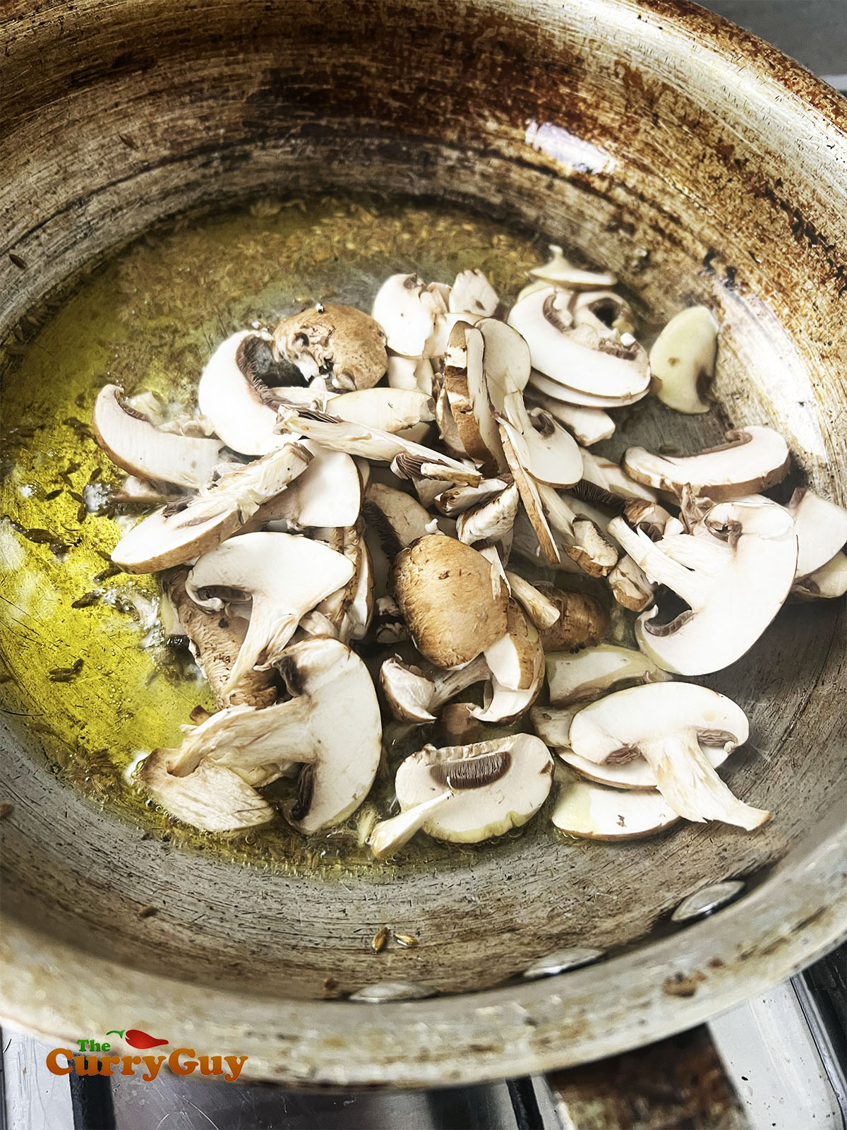 Adding mushrooms to the pan.