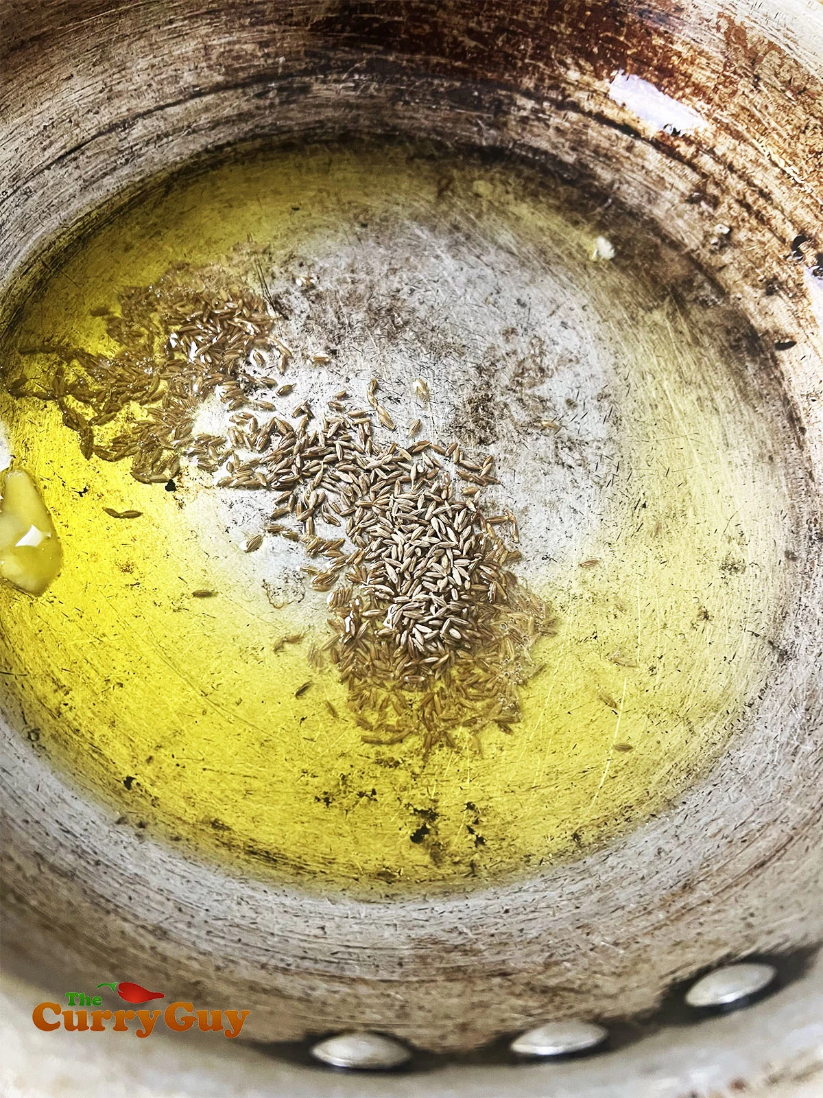Adding the cumin seeds to the hot ghee