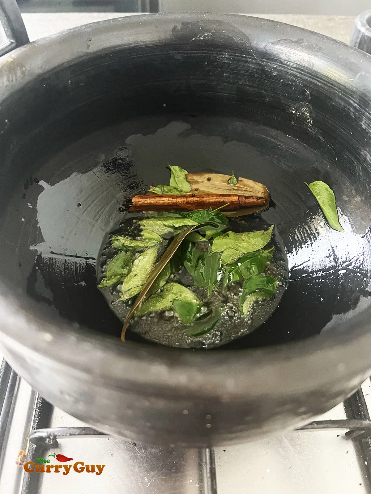 Infusing the curry leaves and whole spices in the pan