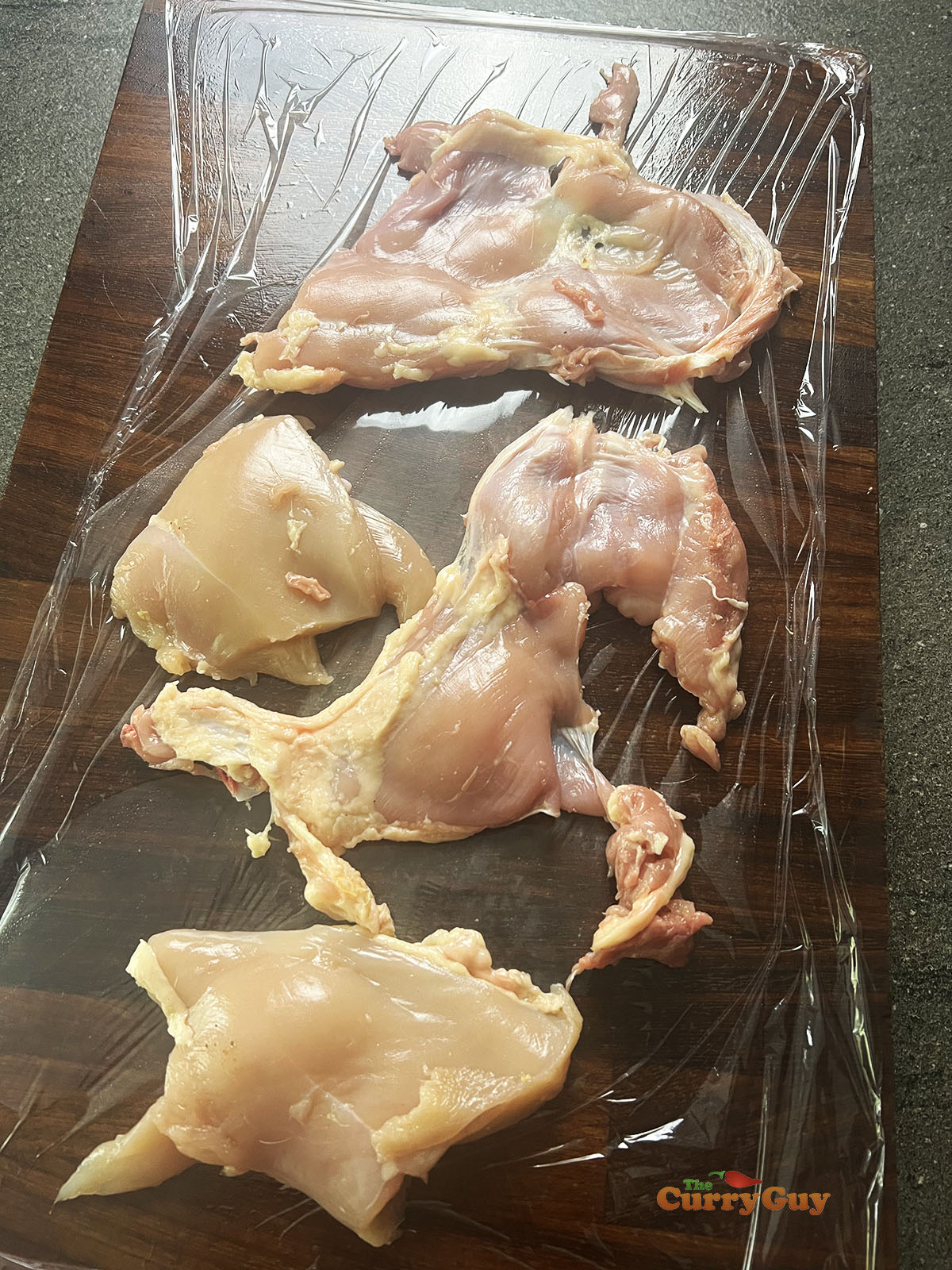 Chicken pieces on clingfilm.