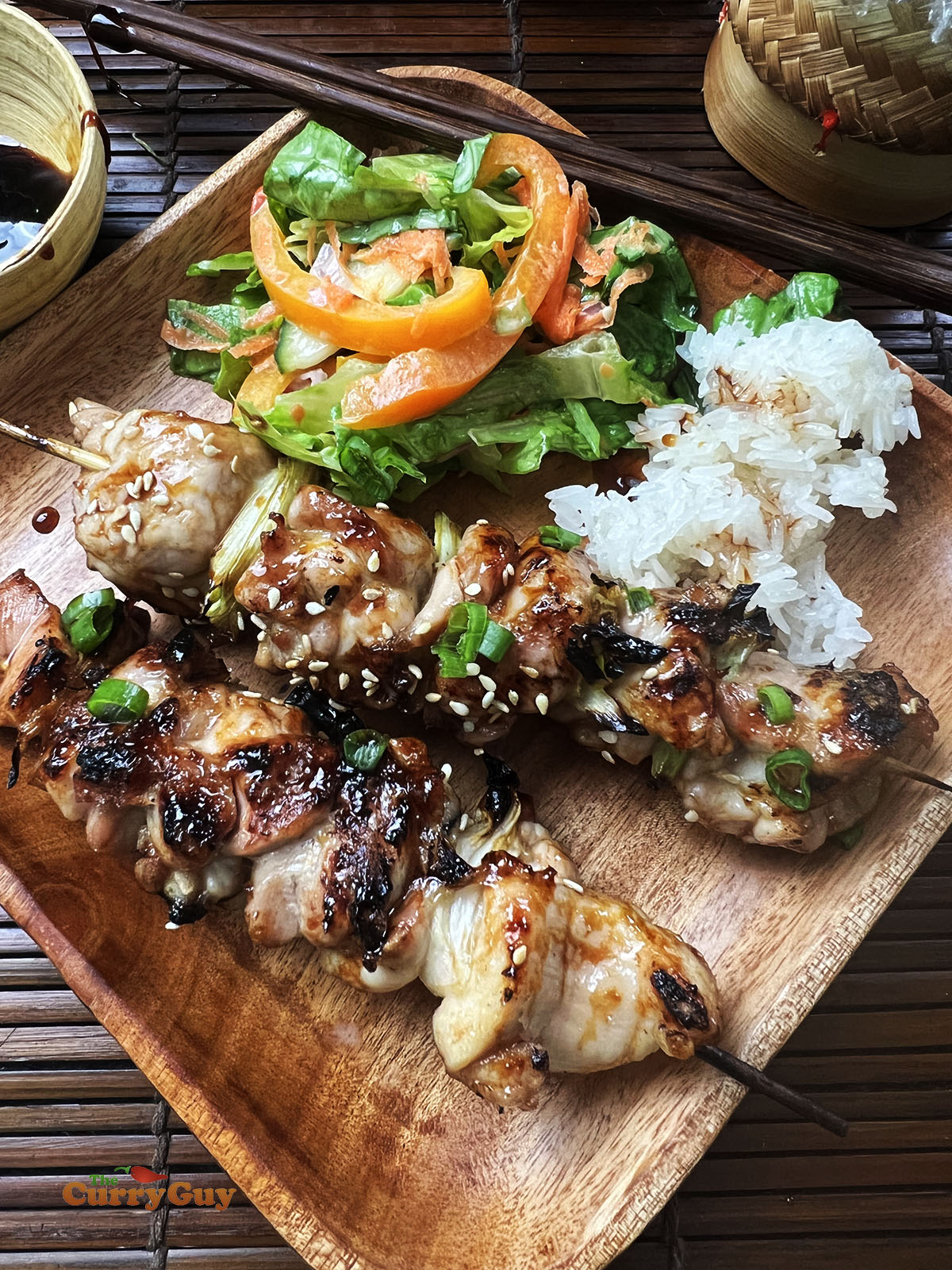 Chicken skewers served with rice and salad.