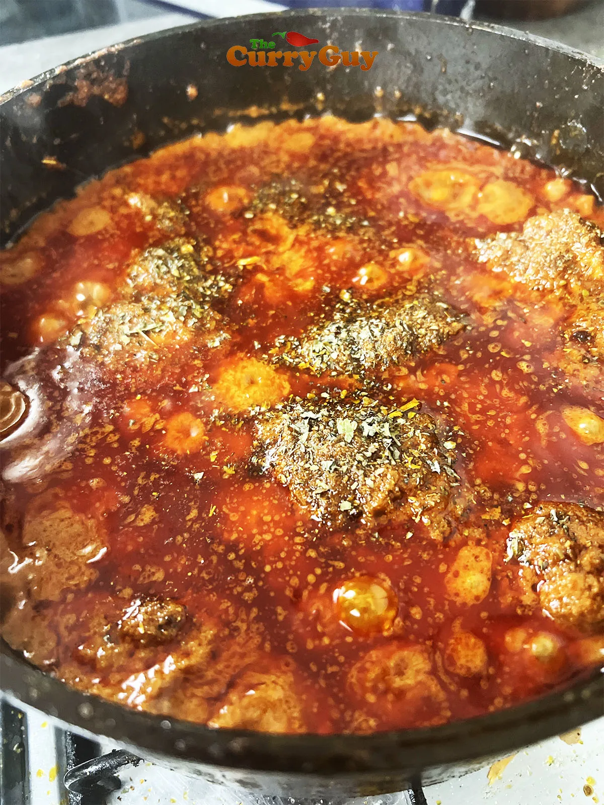 Adding the cooked chicken, kasoori methi and garam masala to the gravy.