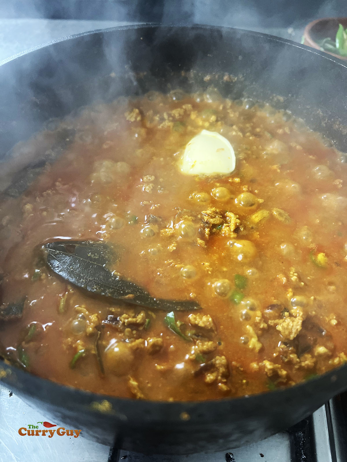 Adding butter and salt to taste to finish the keema curry.