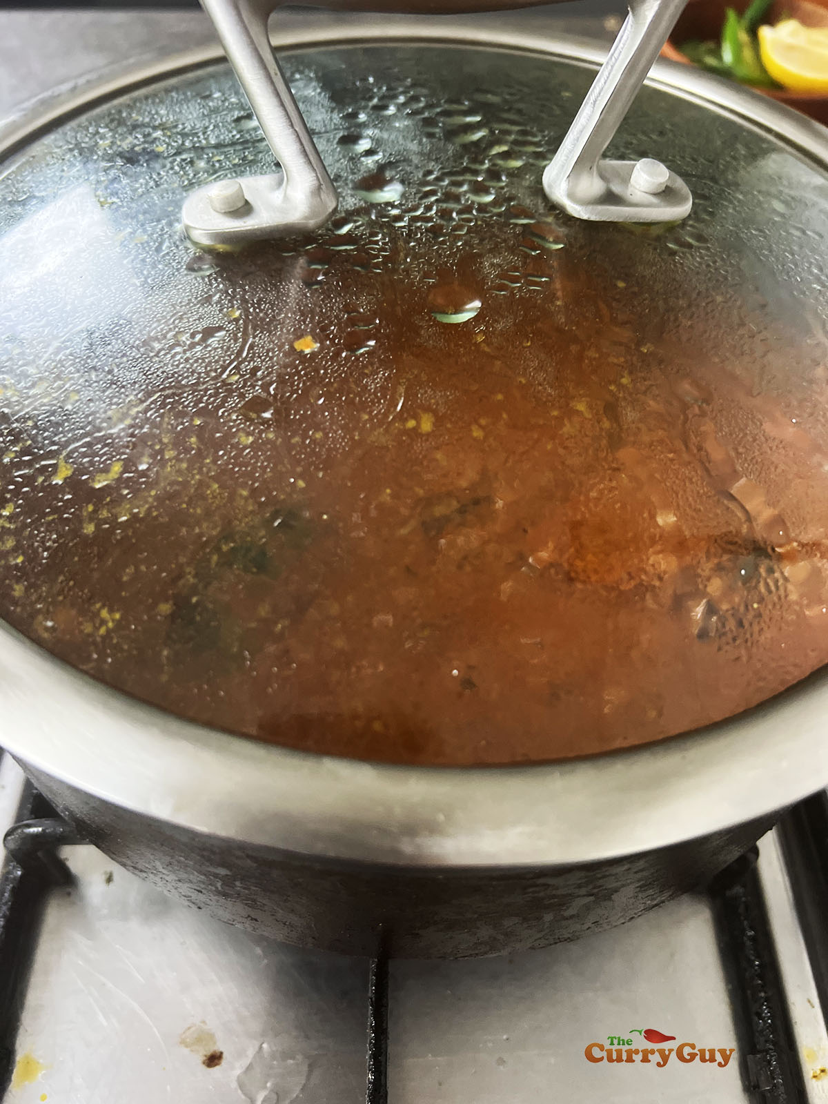 Sauce simmering covered over a low heat.